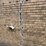 Brick Wall Before Repairs - A large crack in the brick and mortar on the side of a house - Brick and Mortar Repair by Lonestar Masonry Repair